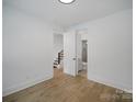 Bright, minimalist bedroom featuring hardwood floors with an ensuite bathroom at 2534 Park Rose Ln # 11, Charlotte, NC 28204
