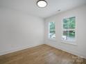 Light-filled bedroom with hardwood floors and two windows offering bright natural light at 2538 Park Rose Ln # 10, Charlotte, NC 28204