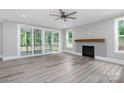 Bright living room featuring sliding glass doors, fireplace, ceiling fan and wood-look flooring at 4251 Candlewood Dr, Sherrills Ford, NC 28673