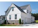 Attached two-car garage featuring white doors, siding, and stone accents on a new construction home at 4257 Candlewood Dr # 7, Sherrills Ford, NC 28673