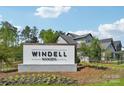 Welcoming Windell Woods community sign set against a backdrop of lush greenery and blue skies at 604 Hyder Trl, Tega Cay, SC 29708