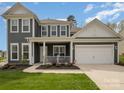 Gray two-story house with white trim, front porch, and attached garage at 8903 Ansley Park Pl, Huntersville, NC 28078