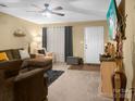 Spacious living room featuring a brown sectional sofa and a large TV at 11627 Tribal Dr, Charlotte, NC 28214