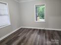 Bright bedroom with neutral walls, wood floors, and window with blinds at 1300 Brookdale St, Kannapolis, NC 28083