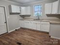 Simple kitchen with white cabinets, wood floors, and neutral walls at 1300 Brookdale St, Kannapolis, NC 28083