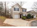 Tan two-story house with a white garage door and landscaping at 1444 Swaying Branch Ln, Clover, SC 29710