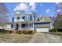 Beautiful two-story blue house with a front porch and two-car garage at 2607 White Pines Ct, Monroe, NC 28112