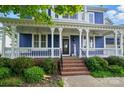 Inviting front porch featuring elegant columns, a porch swing, and a welcoming atmosphere at 2607 White Pines Ct, Monroe, NC 28112