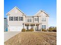 Two-story house with beige siding, a large front yard, and a two-car garage at 10045 Carousel Corral Dr, Midland, NC 28107