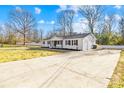 Spacious home featuring a long driveway, a fenced yard, and white brick exterior at 1006 Woodside Dr, Kings Mountain, NC 28086