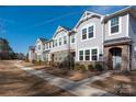 Exterior of townhomes featuring stone accents, manicured lawns, and a sidewalk for pedestrian access at 1342 Galloway Rd # 132, Charlotte, NC 28262