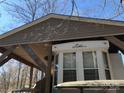 Close-up of mobile home showing a large window, siding, and covered parking area at 140 Landlubber Trl # H73, Mount Gilead, NC 27306