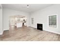 Bright living room with wood floors, fireplace, and an open layout leading to the kitchen at 5230 Club View Dr, Concord, NC 28025