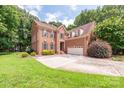 Two-story brick home with attached garage and lush landscaping at 525 Streamside Ln, Waxhaw, NC 28173