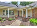 Inviting covered front porch with classic columns, a wood deck, and colorful planters at 7135 Folger Dr, Charlotte, NC 28270