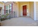 Front porch with dark red door and black metal railing at 900 Raffaelo Vw, Mount Holly, NC 28120