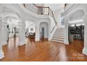 Grand foyer showcasing hardwood floors, staircase, balcony, and open floor plan with natural light at 103 Glenholden Ln, Mooresville, NC 28115
