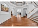 Spacious foyer featuring hardwood floors, staircase, soaring ceilings, and elegant architectural details at 103 Glenholden Ln, Mooresville, NC 28115