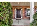 Close-up of the front door and porch, with brick accents and decorative shrubbery at 103 Glenholden Ln, Mooresville, NC 28115