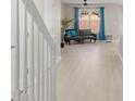 Open living area with hardwood floors and a view down a white staircase at 10841 Twisted Bark Ln, Charlotte, NC 28213