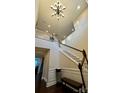 Elegant staircase with a chandelier and hardwood floors at 11519 Sweet Birch Ln, Charlotte, NC 28278