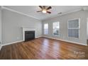 Bright living room featuring a fireplace, ceiling fan, wood floors and natural light at 11615 Kingsley View Dr, Charlotte, NC 28277