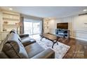 Relaxing living room with hardwood floors, gray sectional sofa, and built-in shelving at 1323 Queens Rd # 407, Charlotte, NC 28207