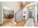 Two-story entryway with hardwood floors and an elegant staircase at 15604 Wynford Hall St, Huntersville, NC 28078