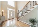 Bright entryway with hardwood floors, featuring a staircase and front door at 15604 Wynford Hall St, Huntersville, NC 28078