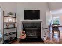 Living room featuring fireplace, guitar, shelving, and television at 2502 Cranbrook Ln # 4, Charlotte, NC 28207