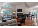 Open-concept living room with a fireplace, vaulted ceilings, natural light, and an adjacent dining area at 2502 Cranbrook Ln # 4, Charlotte, NC 28207