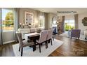 Open concept dining room with hardwood floors, a view of the backyard, and seating for four at 3719 13Th Ne St, Hickory, NC 28601