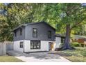 Modern two-tone exterior with a spacious driveway and mature tree at 3801 Woodleaf Rd, Charlotte, NC 28205