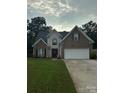 Brick two-story house with a large driveway and landscaped lawn at 4305 Chatterleigh Dr, Monroe, NC 28110