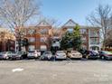 Three-story brick building with assigned parking and lovely mature landscaping on a sunny day at 5617 Fairview Rd # 9, Charlotte, NC 28209