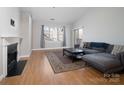 Cozy living room with a fireplace, hardwood floors, and large windows offering ample natural light at 5617 Fairview Rd # 9, Charlotte, NC 28209