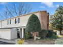 Tan and brick townhouse with a tree and gated entrance at 5915 Quail Hollow Rd # E, Charlotte, NC 28210