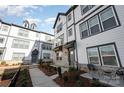 Modern townhome with gray and white exterior, brick accents, and a charming walkway at 6027 Towering Oaks Dr, Charlotte, NC 28205