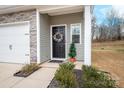 Modern black front door with a wreath, located on a stone-accented home at 7216 Somerford Rd, Charlotte, NC 28215