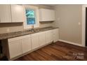 White kitchen cabinets, granite countertops, and a double sink at 1302 Brookdale St, Kannapolis, NC 28083