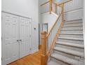 Elegant staircase with a wooden handrail and carpeted steps at 14214 Sullivan Watch Dr, Huntersville, NC 28078