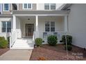 Front porch with white columns and steps, and landscaping at 2010 Belle Grove Dr, Marvin, NC 28173
