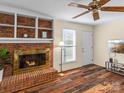 Cozy living room with a brick fireplace, wood floors, and a ceiling fan at 3 Old Farm Rd, Salisbury, NC 28147