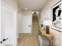 Inviting entryway with light hardwood floors, modern decor, and a staircase leading to the upper level at 309 Old Town Village Rd, Waxhaw, NC 28173