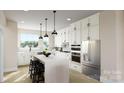 Stylish kitchen with white cabinets, stainless steel appliances, a large island, and modern pendant lighting at 309 Old Town Village Rd, Waxhaw, NC 28173