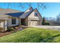 Home's exterior features light beige siding, a two-car garage, and a well-manicured lawn at 3976 Stadler Ne Dr, Conover, NC 28613
