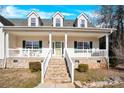 Front view of a two story house with a white porch and stonework at 7918 Ridgeview Dr, Sherrills Ford, NC 28673