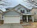 Charming two-story home with gray siding, black shutters, and an attached two-car garage at 9034 Seamill Rd, Charlotte, NC 28278