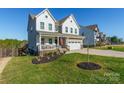 Two-story home with a front porch, landscaping, and a large driveway at 14450 Maritime Dr, Lancaster, SC 29720