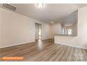 Open-concept living room with wood-look floors and access to the kitchen with a countertop bar area at 1630 Troon Dr, Salisbury, NC 28144